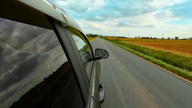 Driving SUV along rural road in England countryside. Moving sport utility vehicle through country lane in Great Britain. Travelling crossover down scenic village roadway in UK
