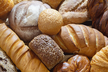Assorted fresh bread varieties displayed artfully on a neutral background, showcasing textures