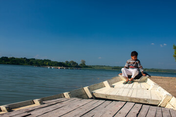 young man sitting on a pier
