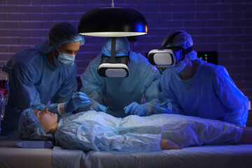 Surgeons with VR glasses operating patient in clinic