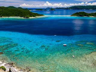 青い海の白砂のビーチが美しい無人島、嘉比島のドローン撮影（沖縄県島尻郡慶良間諸島座間味島嘉比島） 島には白い灯台がある。 座間味島や渡嘉敷島、阿嘉島も見えている。
2025/6/27
