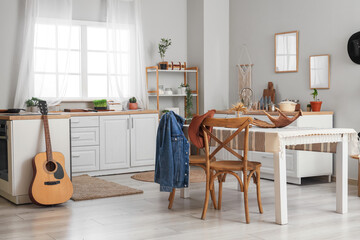 Interior of kitchen with dining table, cowboy hat and denim jacket on chairs