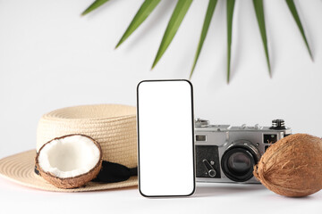 Mobile phone with camera, hat and coconut on white background