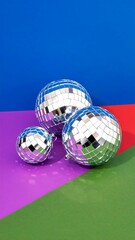Three disco balls on a colorful background