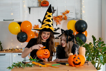 A happy family is getting ready for Halloween. Mother and child daughter in carnival costumes at...