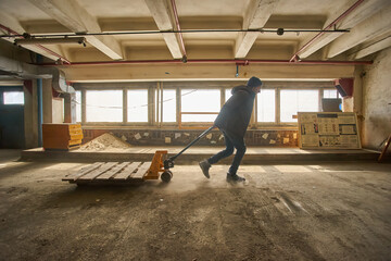 Worker with Pallet Jack in Warehouse