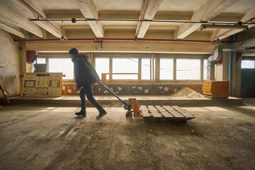 Worker with Pallet Jack in Warehouse