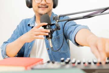Man podcast or radio interview recording, adjust an equalizer while talking with microphone