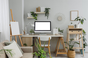Interior of light office with workplace and green plants