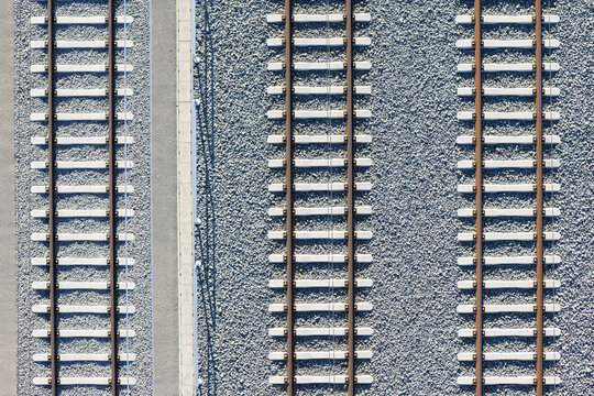 Aerial view of parallel train tracks cutting through a grey gravel bed, Koralmbahn, Deutschlandsberg, Steiermark, Austria.