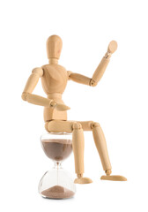 Wooden mannequin sitting on hourglass on white background