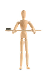 Wooden mannequin holding toothbrush on white background