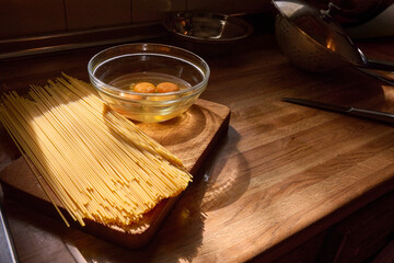 cozy kitchen scene featuring raw spaghetti, a bowl of eggs, and everyday utensils arranged neatly...