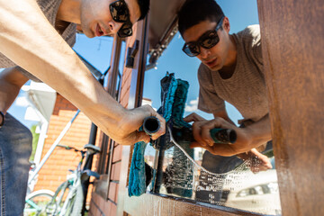 Man washing glass door with squeegee tool