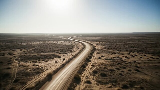 Elevated view of a road winding through a sun-baked, desolate landscape
