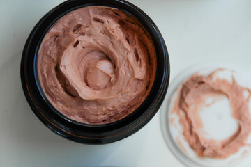 close up of Pink clay face mask in bowl for skincare routine or berry yogurt in bowl 