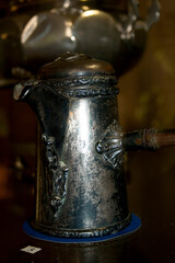 Old coffee pot on a black background, close-up, horizontal
