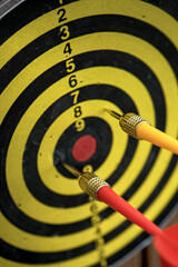 Close up of darts hitting a target board with concentric circles, symbolizing accuracy, goal, and...