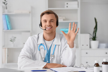 Male doctor in headset giving online consultation at hospital