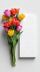 Colorful tulip bouquet beside blank card