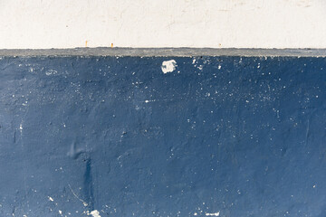 Vintage aged blue wall with white strip with texture showing effects of weather and time. Background photo. Copy space 