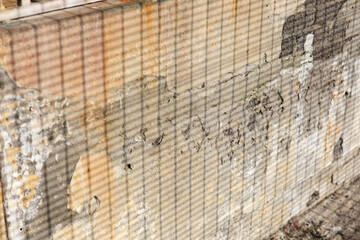 Vintage aged wall with texture showing effects of weather and time and shadow of a fence. Background photo 
