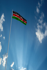 Waving National flag of Kenya on flagpole in sky
