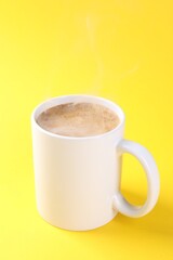 Aromatic coffee in cup on yellow background, closeup. Mockup for design