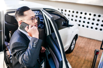 Businessman Talking On Smartphone While Standing Next To Open Car Door