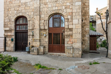 Historic stone building facade in snowy urban setting with arched doors