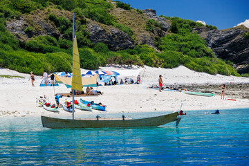 Fototapeta premium 無人島の嘉比島が見える。 白砂のビーチには観光客が上陸している。 パラソルやボート、サバニ（沖縄特有の双胴船）も見える。 船上からも水底の様子が見える。 素晴らしい透明度。 沖縄県島尻郡慶良間諸島座間味島嘉比島-2025/6/27 