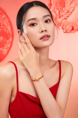 Elegant young woman posing with jewelry in a vibrant setting.