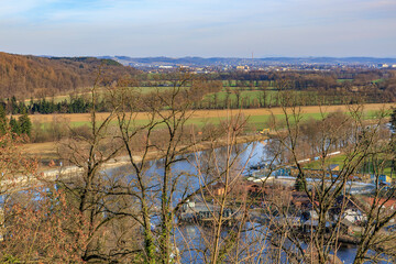 Scenic river view with rolling hills and distant town on a clear day