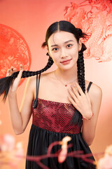 Young woman with braided hair wearing a stylish outfit against a colorful background.