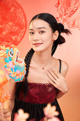 Young woman with braided hair and festive decor in a warm-toned background.