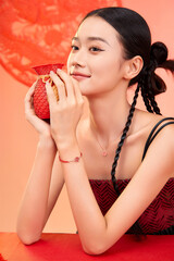 Young woman holding a decorative vase with a traditional design Chinese word means bless.