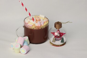 Cocoa with colorful marshmallows and New Year's decorations on a white background — a cozy winter...
