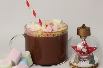 Cocoa with colorful marshmallows and New Year's decorations on a white background — a cozy winter...