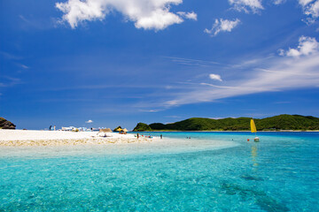 Obraz premium 無人島の嘉比島が見える。 白砂のビーチには観光客が上陸している。 パラソルやボート、サバニ（沖縄特有の双胴船）も見える。 船上からも水底の様子が見える。 素晴らしい透明度。 沖縄県島尻郡慶良間諸島座間味島嘉比島-2025/6/27 