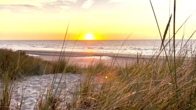 Sonnenuntergang an der Nordsee hinter den D&uuml;nen von De Haan in Belgien