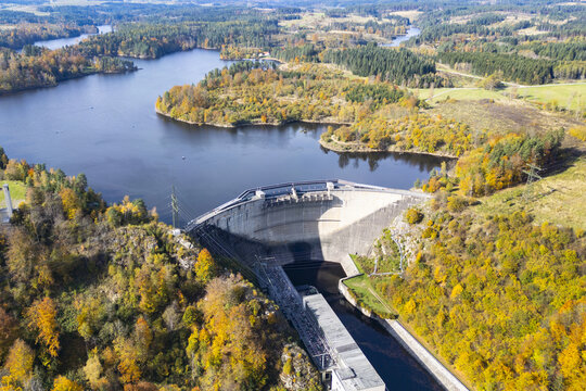 Aerial view of Ottensteiner Stausee dam, a concrete barrier amidst the vibrant autumn foliage, reflecting the clear sky above, Ottenstein, Nieder&Atilde;&para;sterreich, Austria.