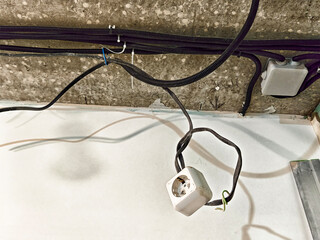 Power outlet and electrical wiring installation inside a modern building during the day
