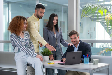 Business team collaborating on laptop in modern office