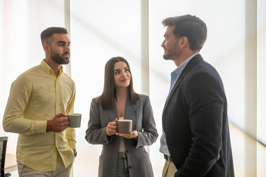 Business team enjoying coffee break and discussing work in office
