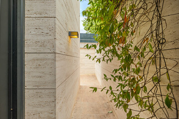 Modern Mediterranean villa with a golden marble facade and a covered porch surrounding walkway