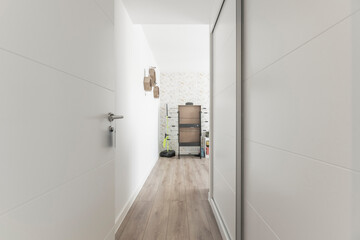 Bedroom wardrobe with white doors and illuminated shelves for displaying shoes and handbags