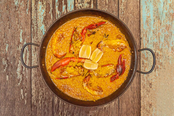 Lobster paella with whole shellfish as a garnish, served directly from the pan to the table