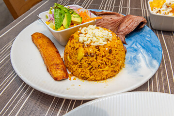 Delicious mostrito from Lima showing its layers: crispy bread underneath, seasoned beef, a golden egg, and aji amarillo sauce oozing around the edges