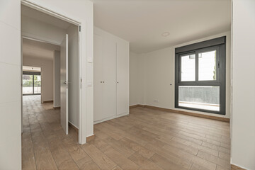 Unfurnished master bedroom with luxurious high-gloss white walk-in closet, beveled mirror doors, and crystal handles