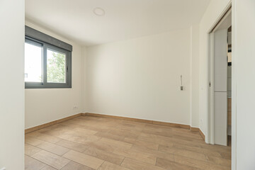 Open-plan room with dark wood flooring, creating a modern contrast with the white walls